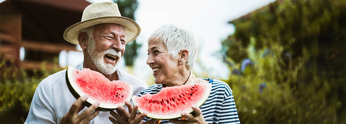 A mature couple enjoying watermelon after a denture cleaning